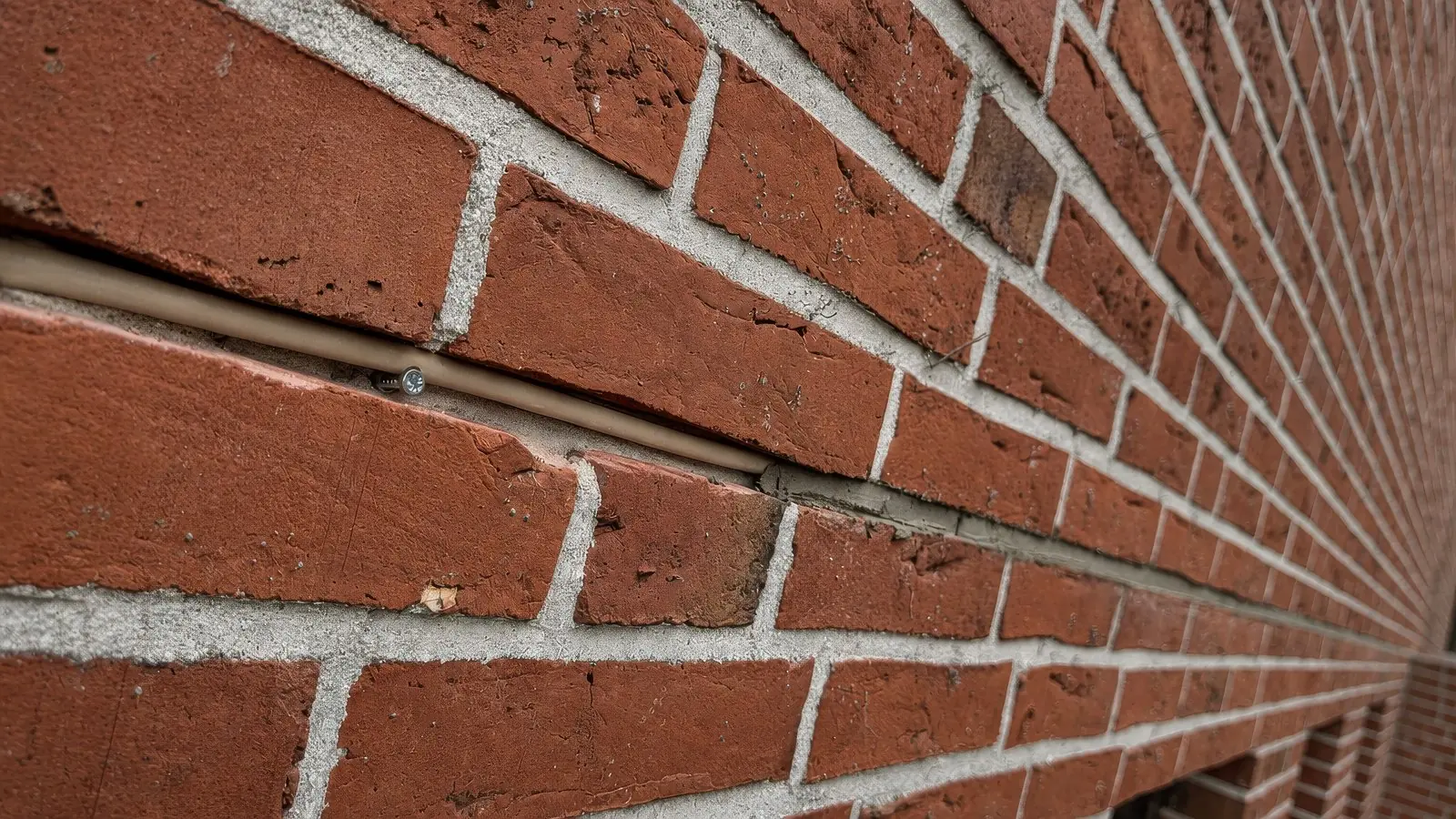 Netzwerkkabel unsichtbar in der Mörtelfuge einer Klinkerwand verlegt